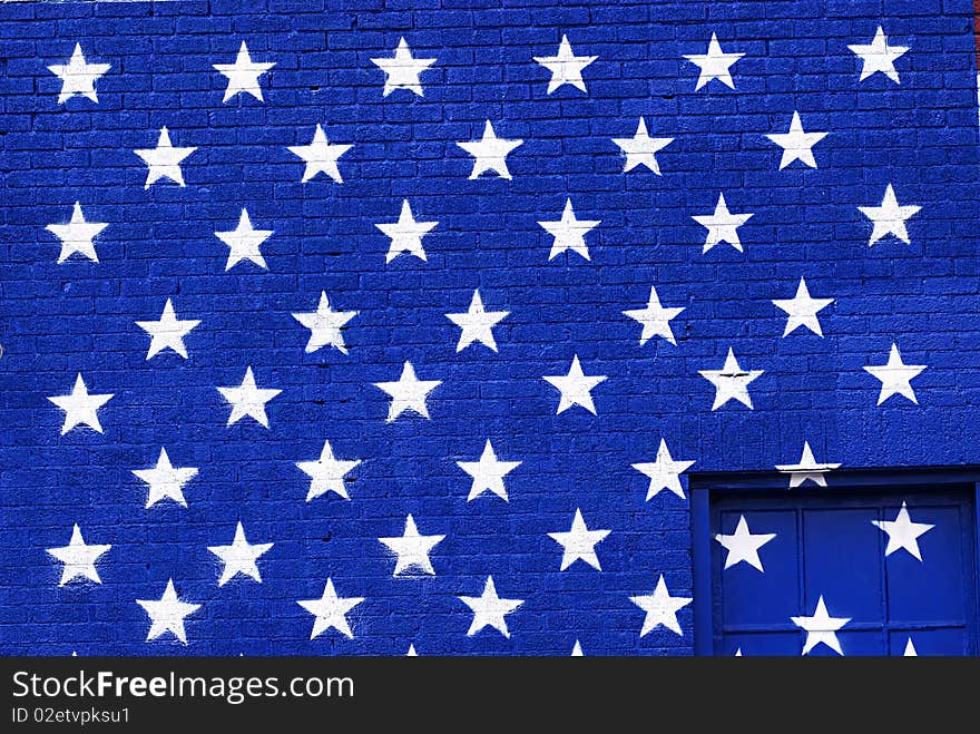 Graffiti styled grunge painted american flag stars on a blue brick background. Graffiti styled grunge painted american flag stars on a blue brick background