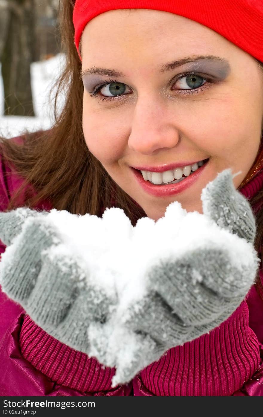 Portrait of young smiling woman blowing snow. Portrait of young smiling woman blowing snow