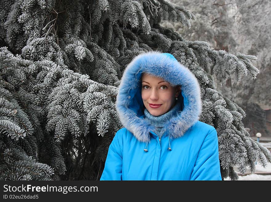 The red-haired girl against the frozen fur-tree branches. The red-haired girl against the frozen fur-tree branches