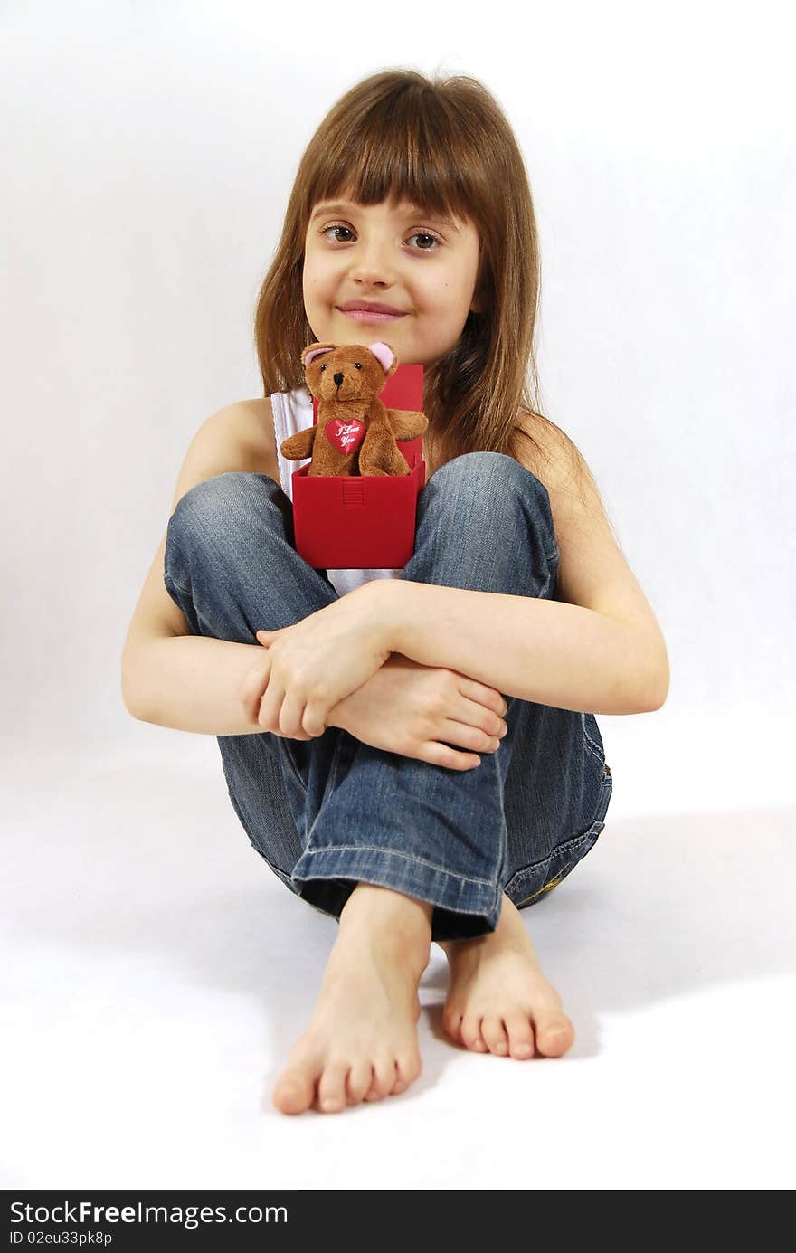 Sitting girl with the toy on knees