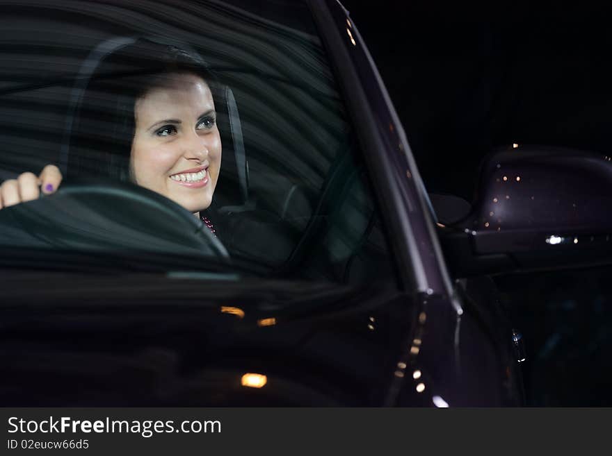 Young beautiful woman driving a car and smiling. Young beautiful woman driving a car and smiling