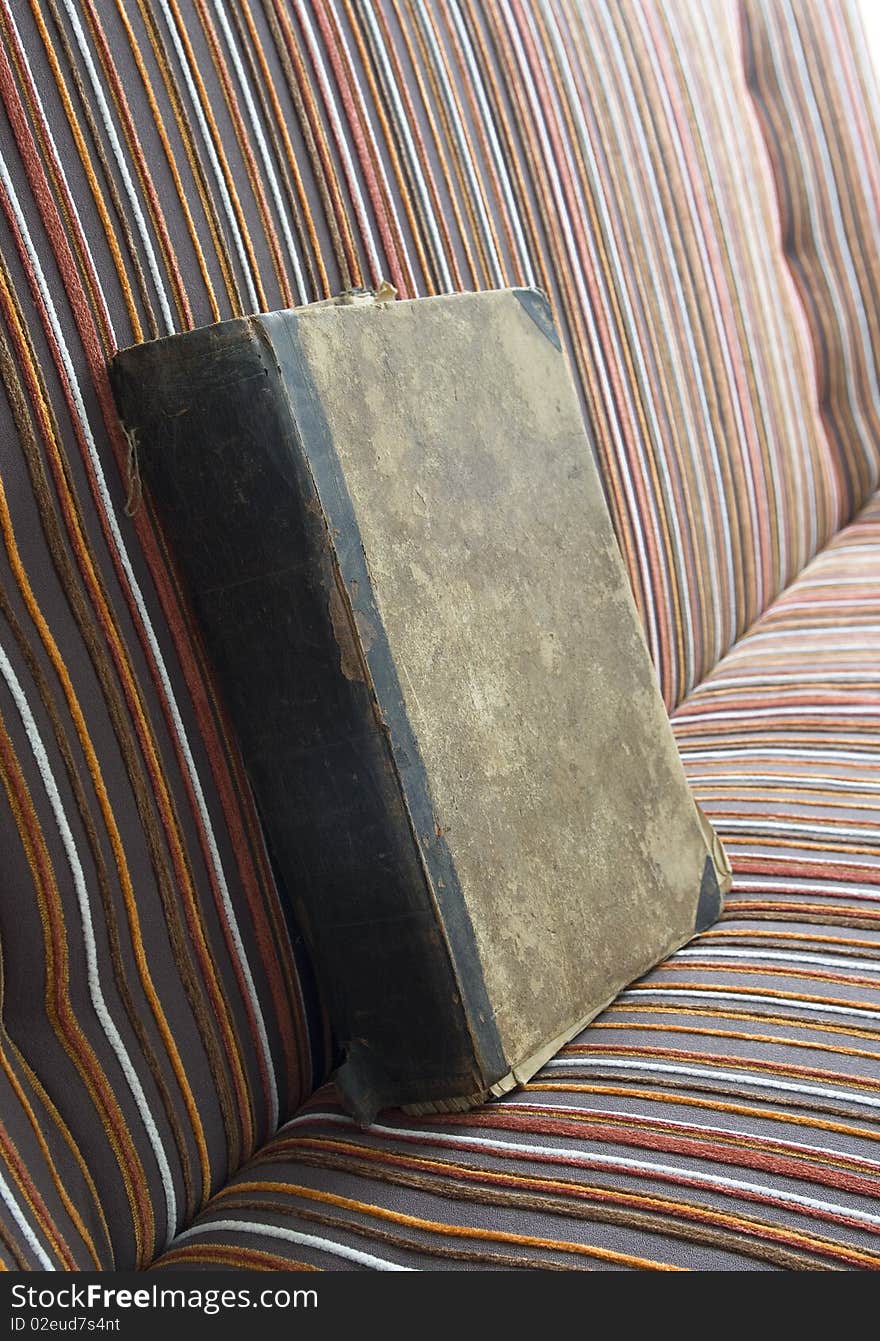 Antique book on the striped bed. Antique book on the striped bed.