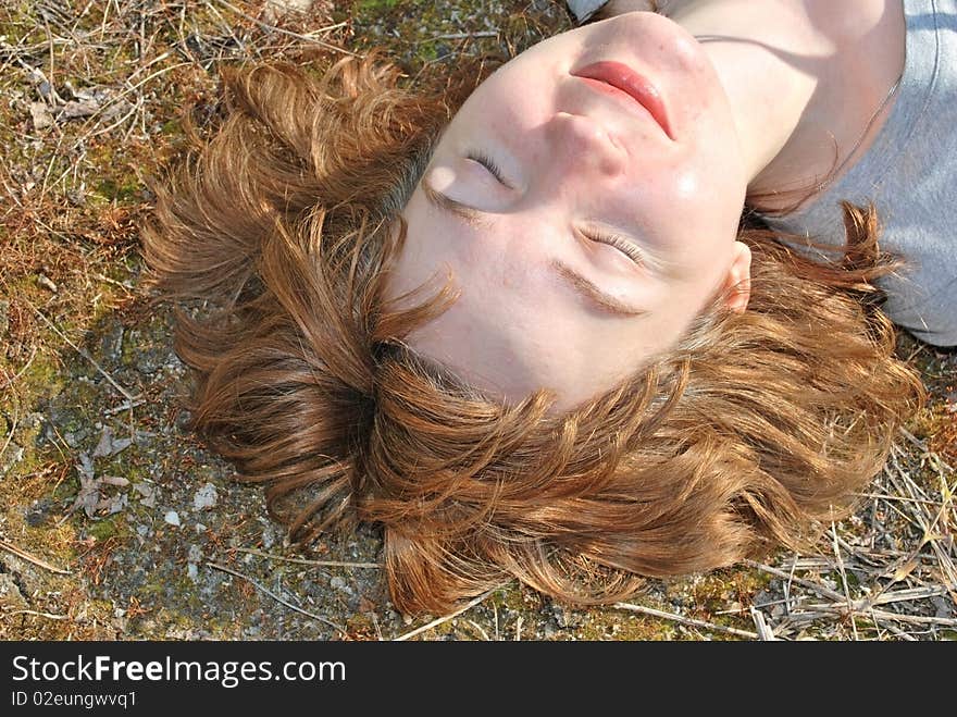 Young woman lie on summer moss lawn