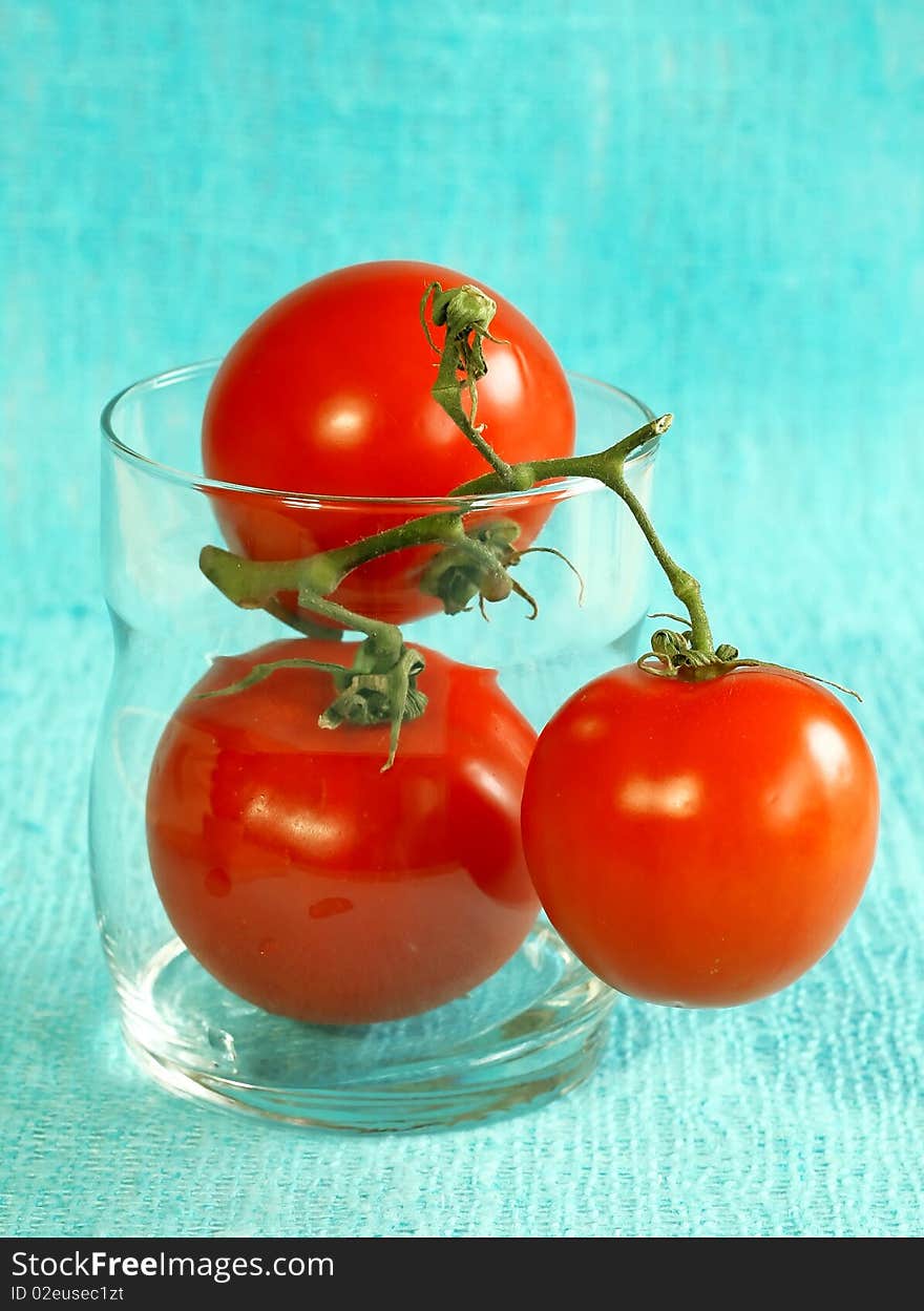 Fresh Tomatoes In Glass On Blue