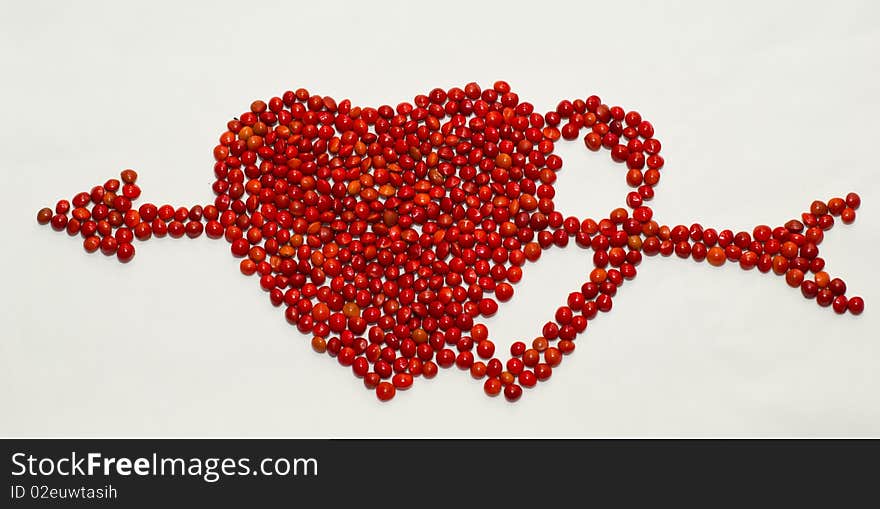 Two hearts with an arrow composed of seeds of red sandalwood