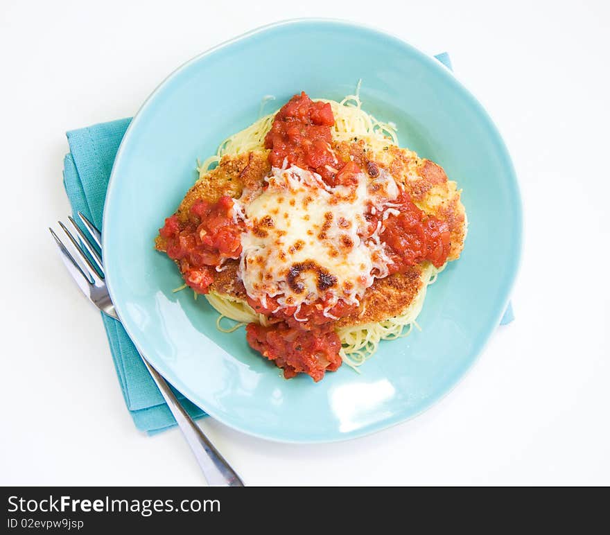 Chicken parmesan with a thick sauce served over pasta