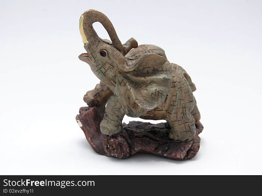 A tiny elephant figurine on a white background.