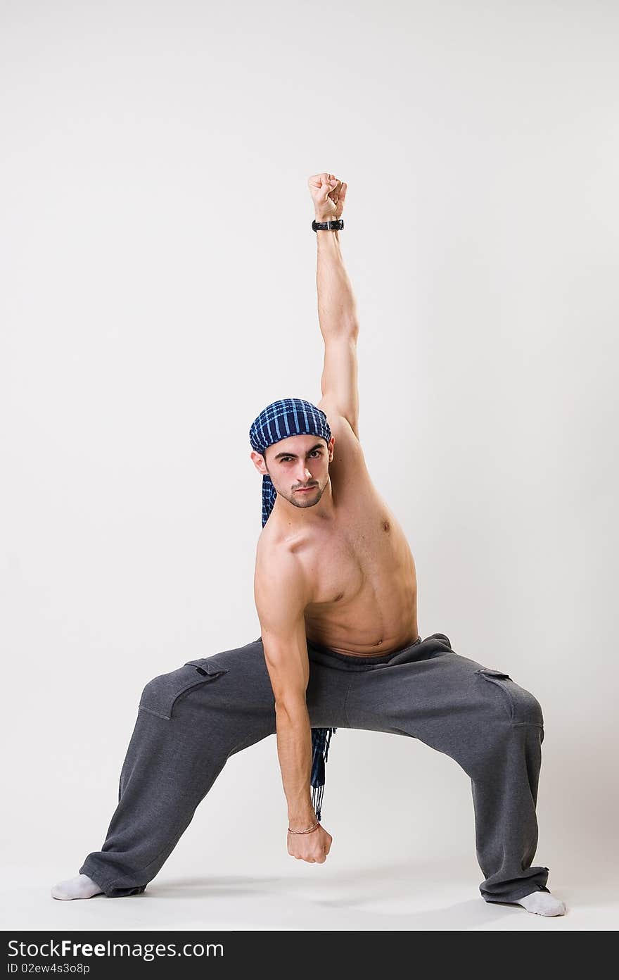 Young athletic dancer exercising, studio shot