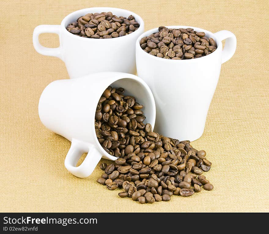 Fresh coffee beans in three white cups