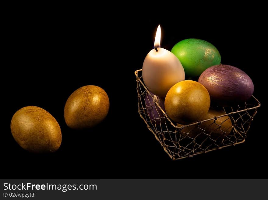 Still life with easter eggs and burnind egg candle in basket on black background. Still life with easter eggs and burnind egg candle in basket on black background