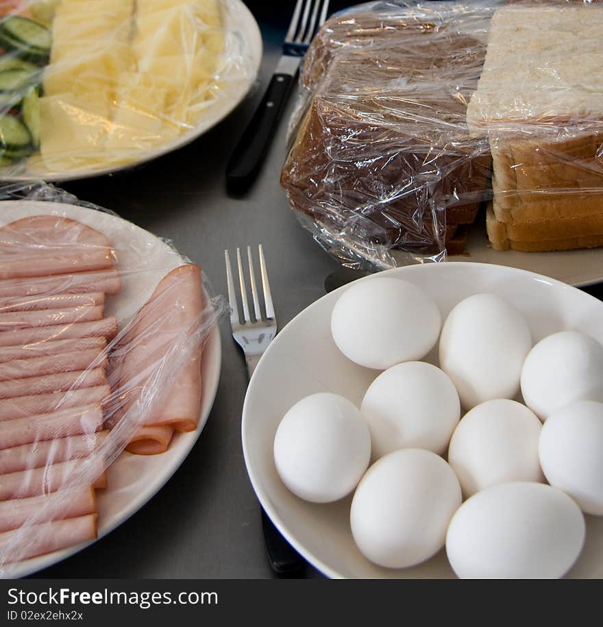 Eggs and bread and ham and cucumber and cheese covered with plastic. Eggs and bread and ham and cucumber and cheese covered with plastic.