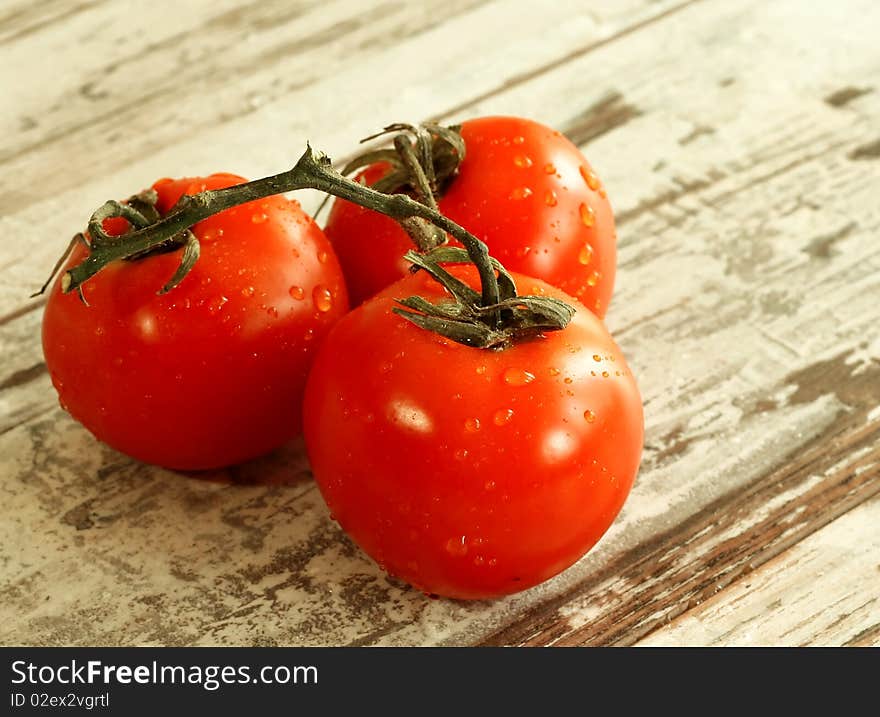 Tomatoes with water drops on wooden