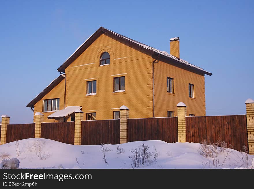 Large house in the winter against the blue sky