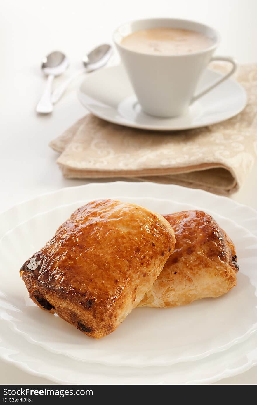 Plate of pain au chocolat and cup of cappuccino