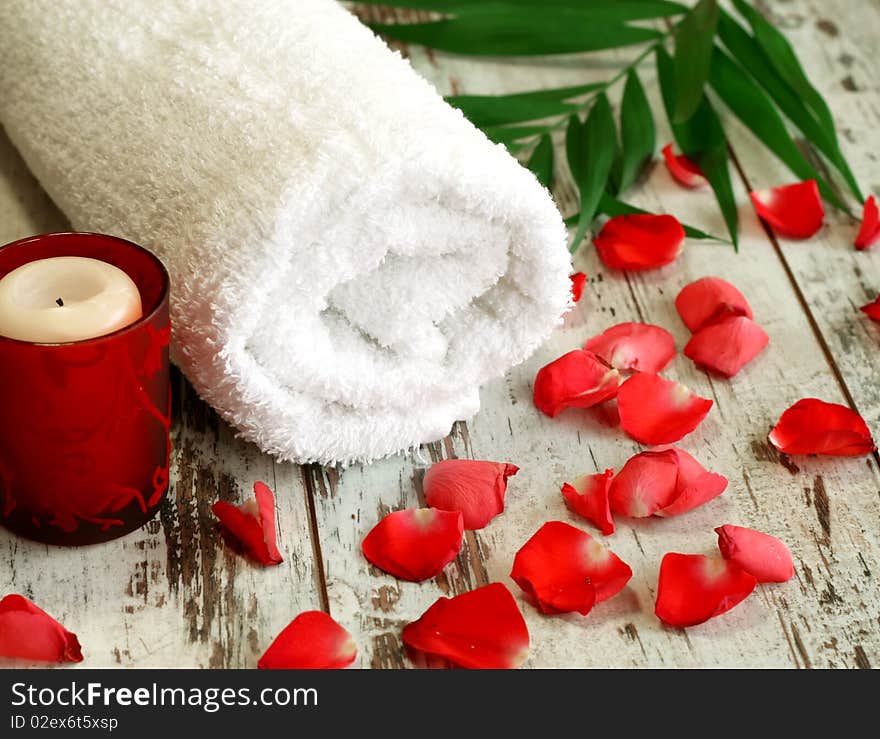 Spa Composition Of Towel, Candle And Red Petals