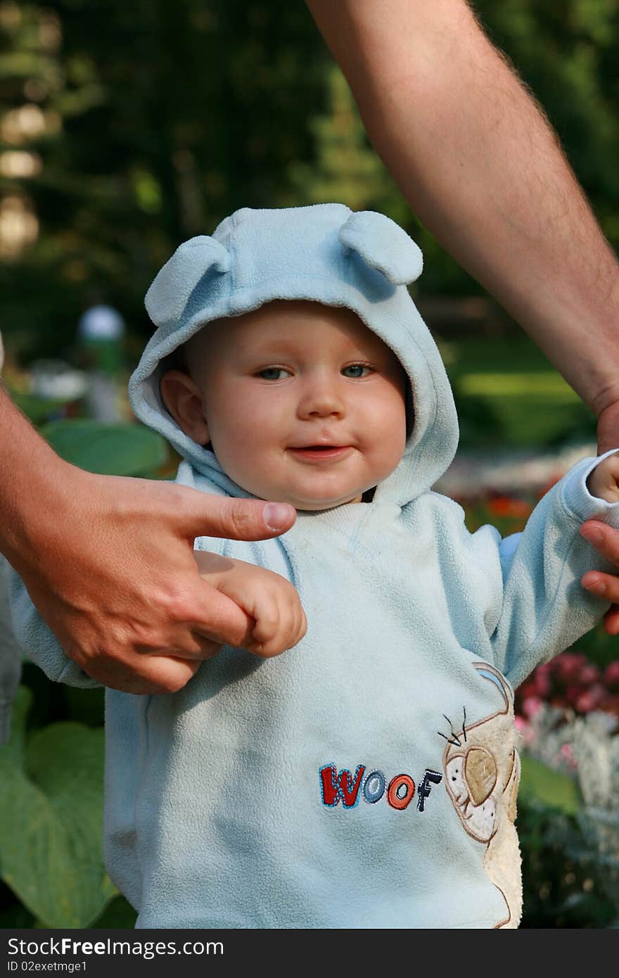 Father or mother and son walking. Father or mother helping child. Seven months old baby boy and his first steps.