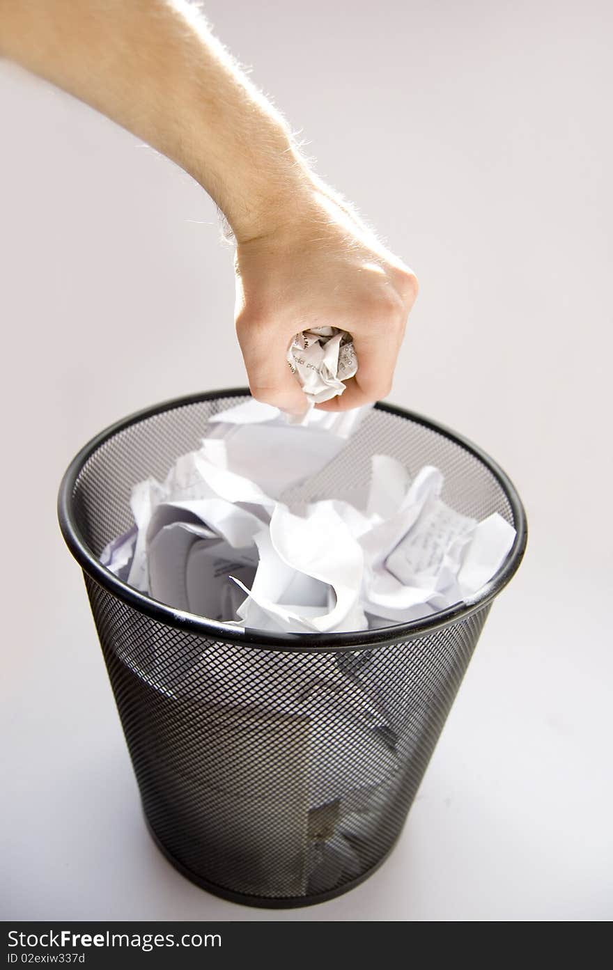 Garbage conceptual image. Man throws paper into a full garbage.