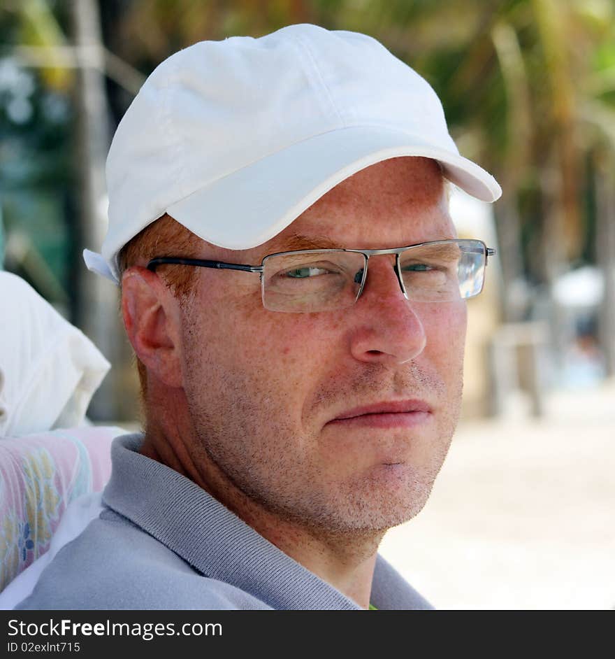 Thoughtful man with white cap on the beach