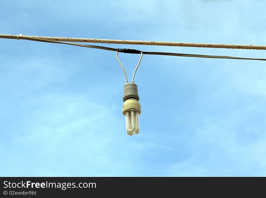 Low energy light bulb hanging in wires outside