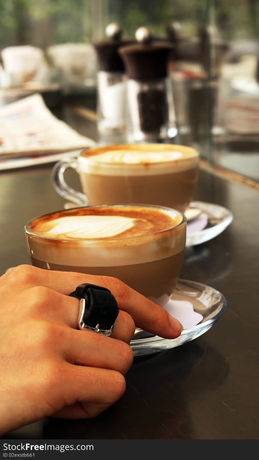 Two cups of coffee and woman's arm