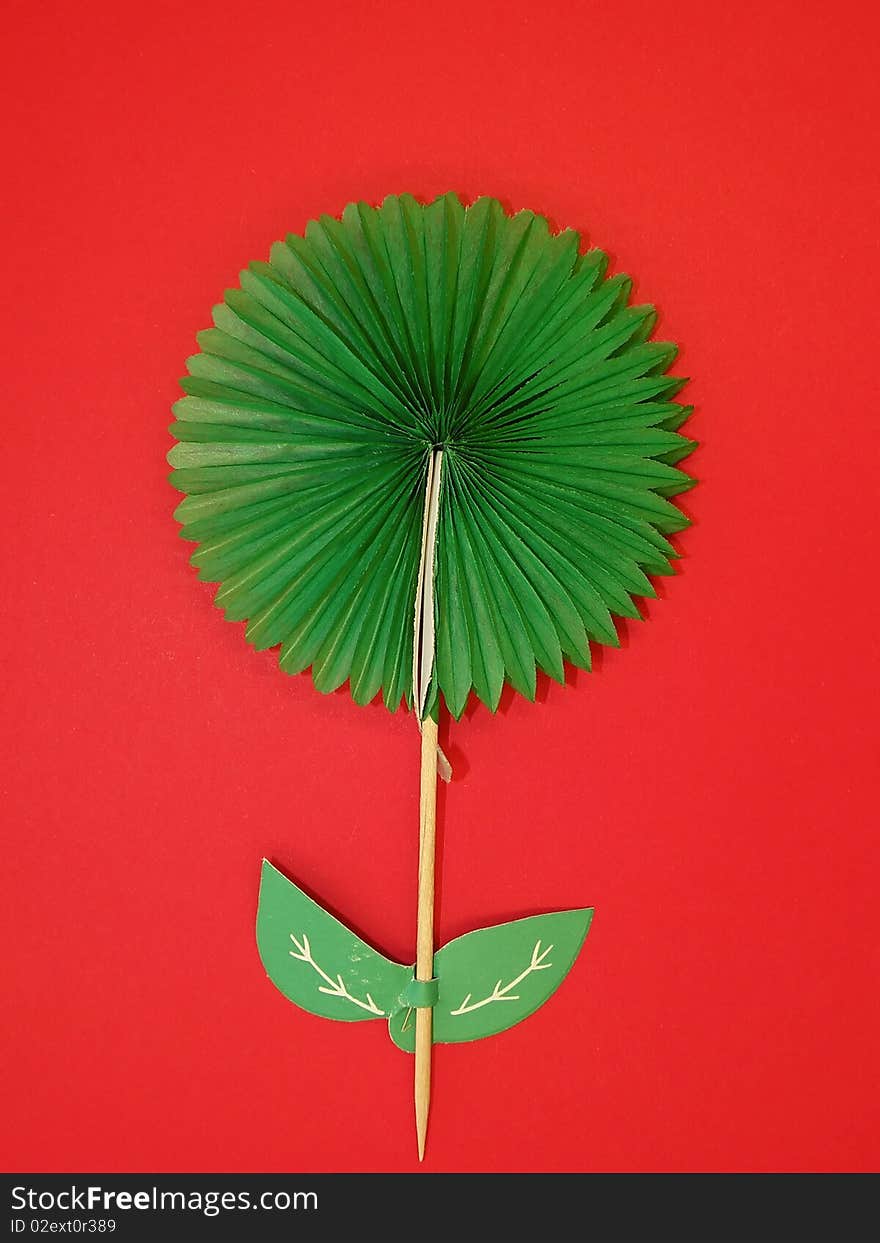 Green paper flower isolated on red