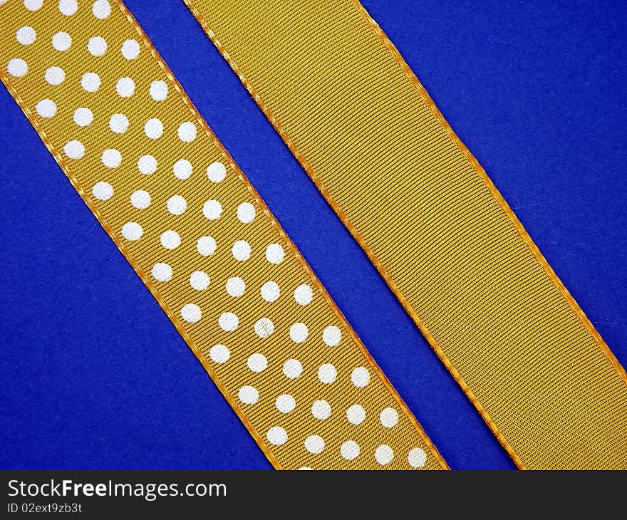 Dotted yellow ribon isolated on blue. Dotted yellow ribon isolated on blue