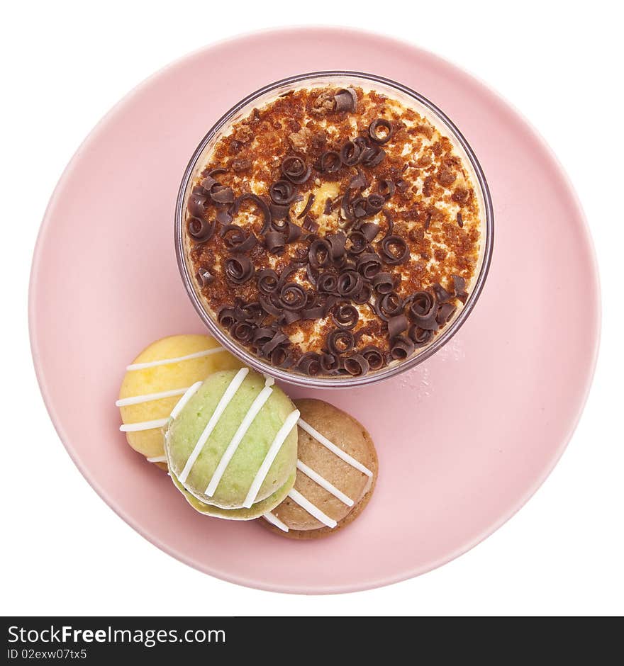 Custard dessert with chocolate topping on a plate with several small cakes.  Isolated on white with a clipping path.