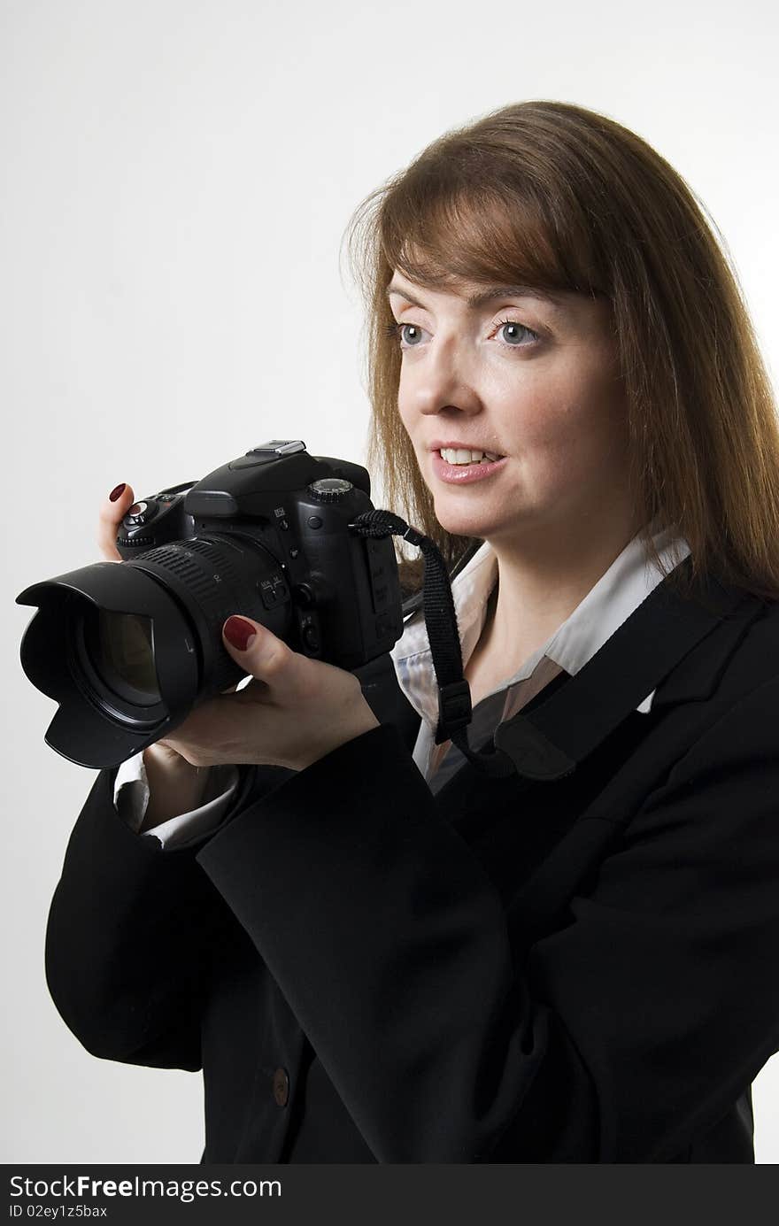 A vertical image of a pretty female photographer holding her camera and smiling. A vertical image of a pretty female photographer holding her camera and smiling