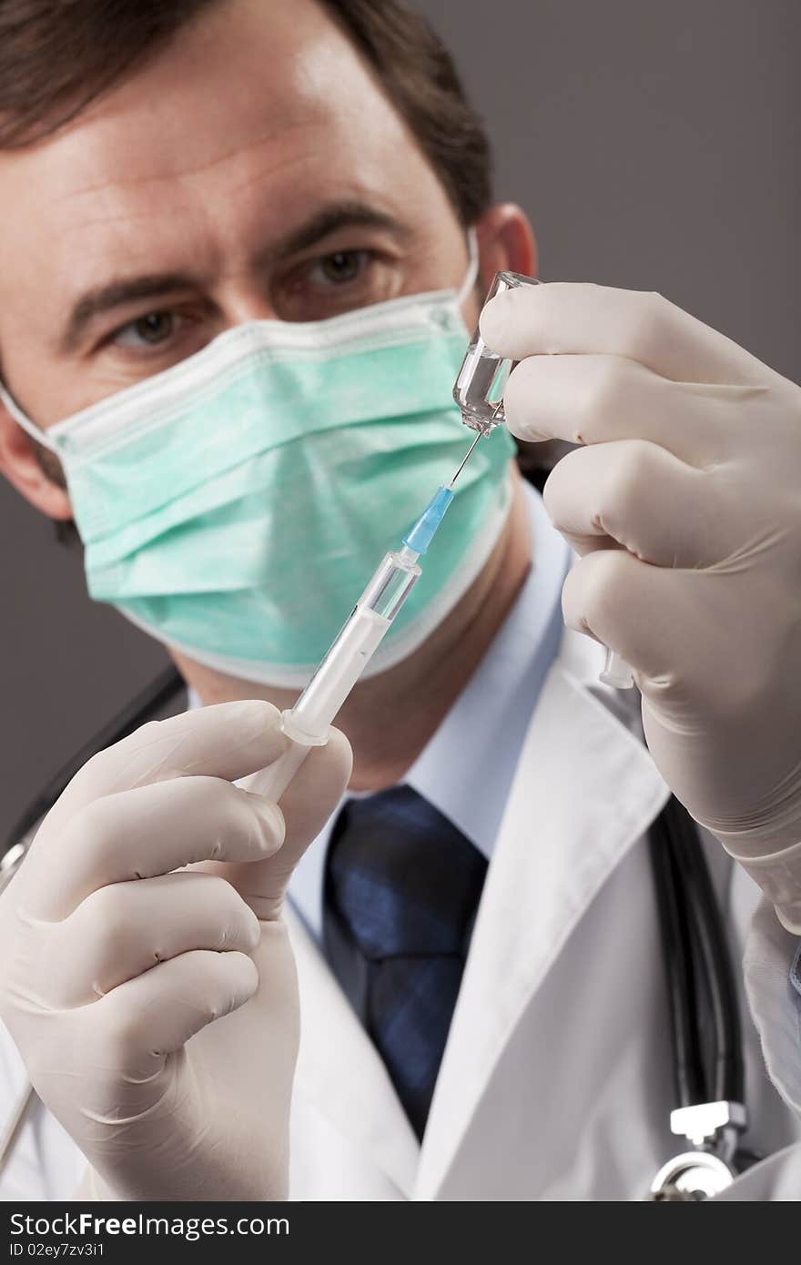 Doctor with medical syringe in hands