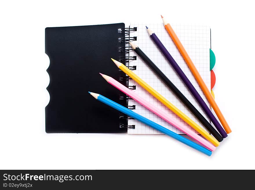 Notebook with a spring and pencils on a white background