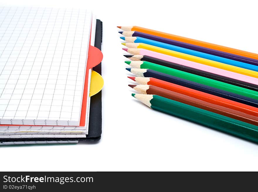 Notebook with a spring and pencils on a white background