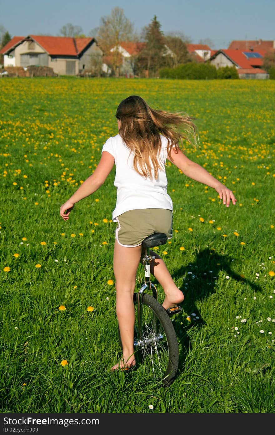 Young girl in field with her monocycle