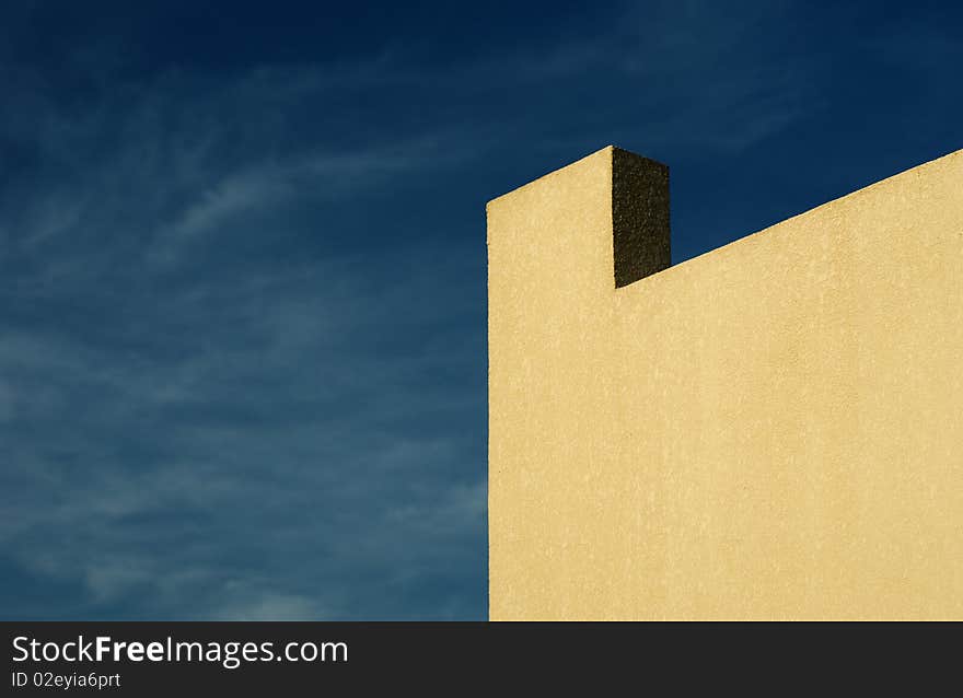 Уellow wall and cloudy sky