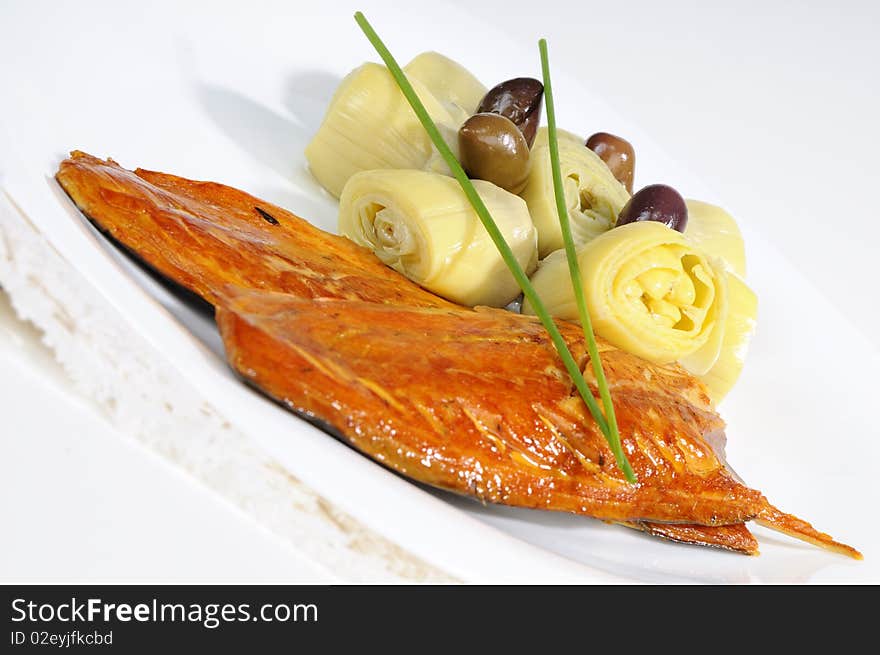 Closeup with fish, onions and olives on white plate. Closeup with fish, onions and olives on white plate