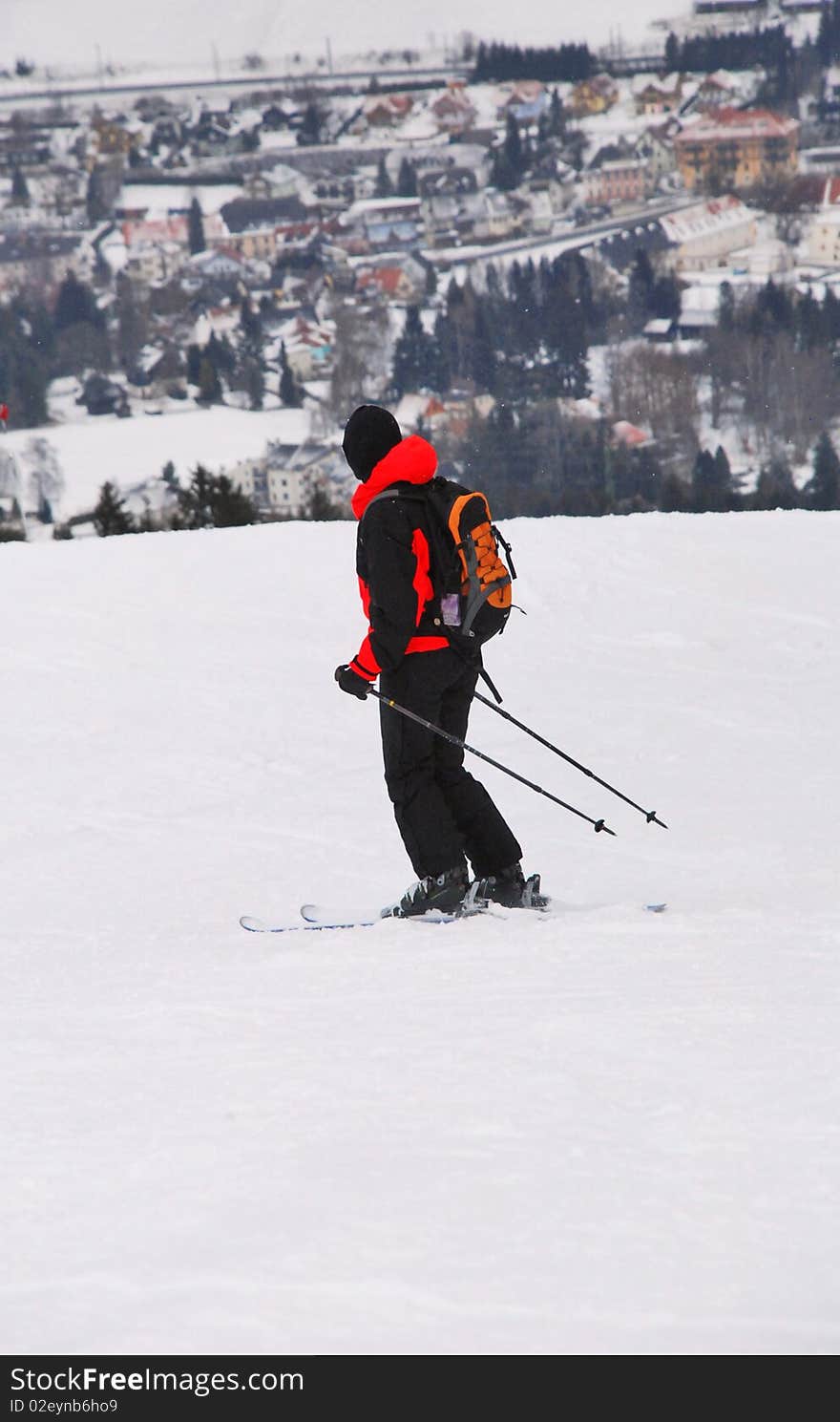 One skier on the slope with village on the background