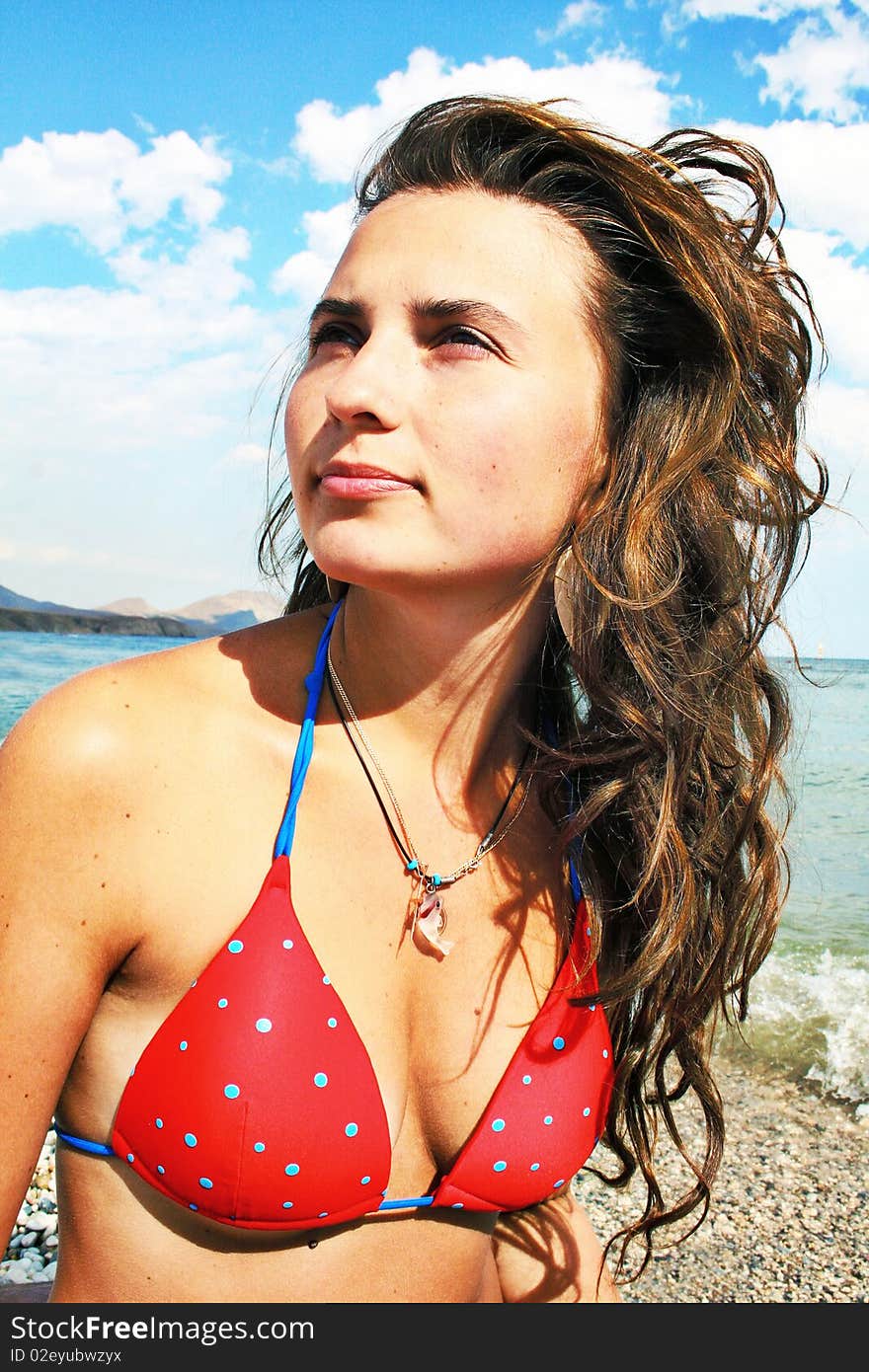 Beautiful girl  in  red swimsuit on a beach