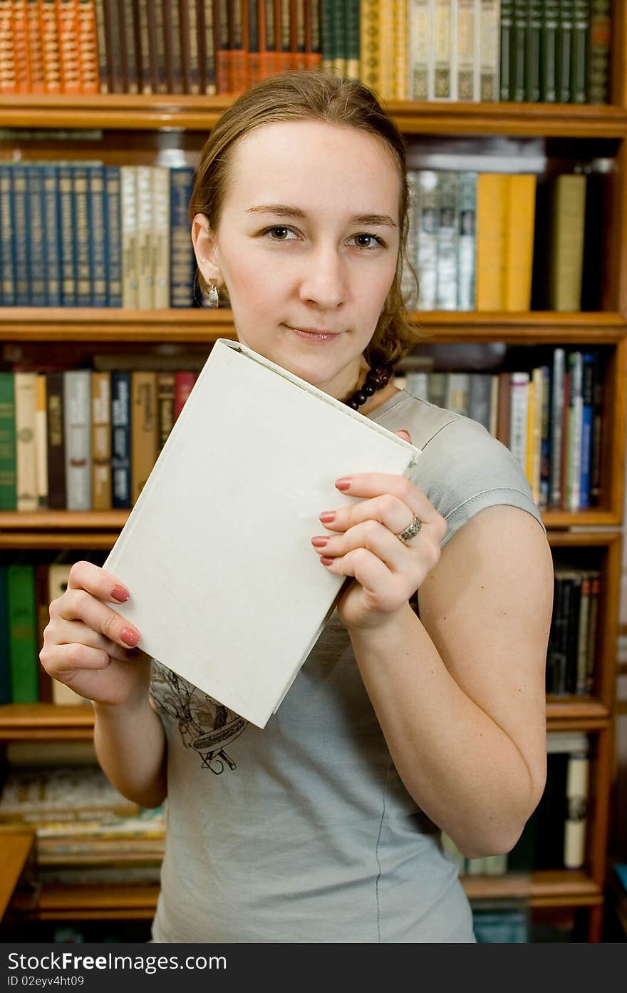 Young woman with a book  in a library