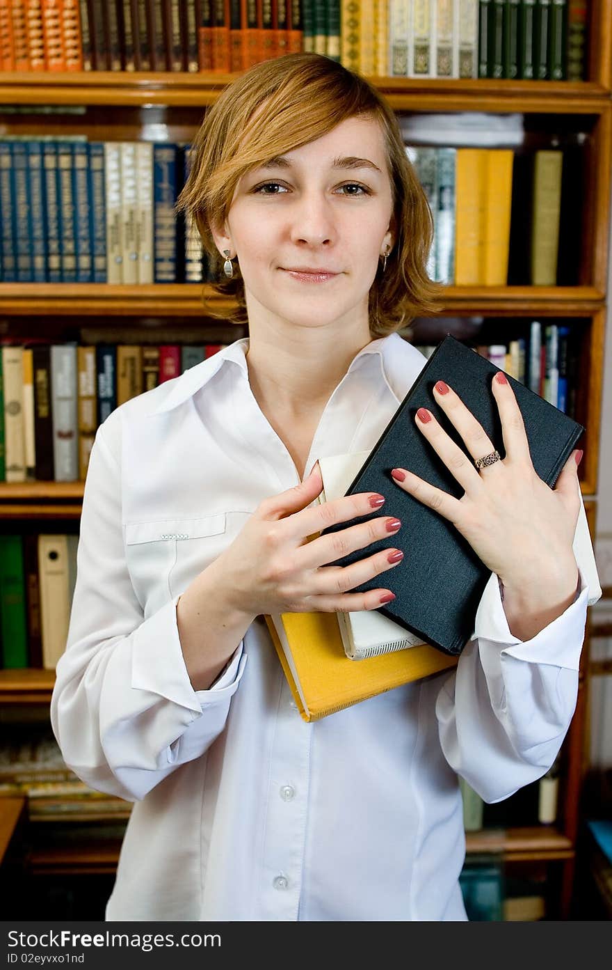 Young woman with a book  in a library