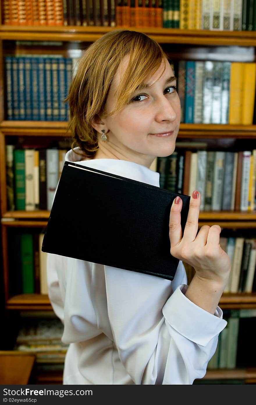 Young woman with a book  in a library