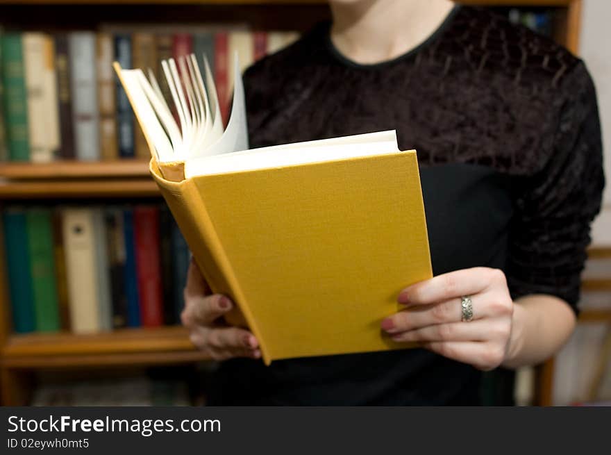 Book in hands at a woman in a library