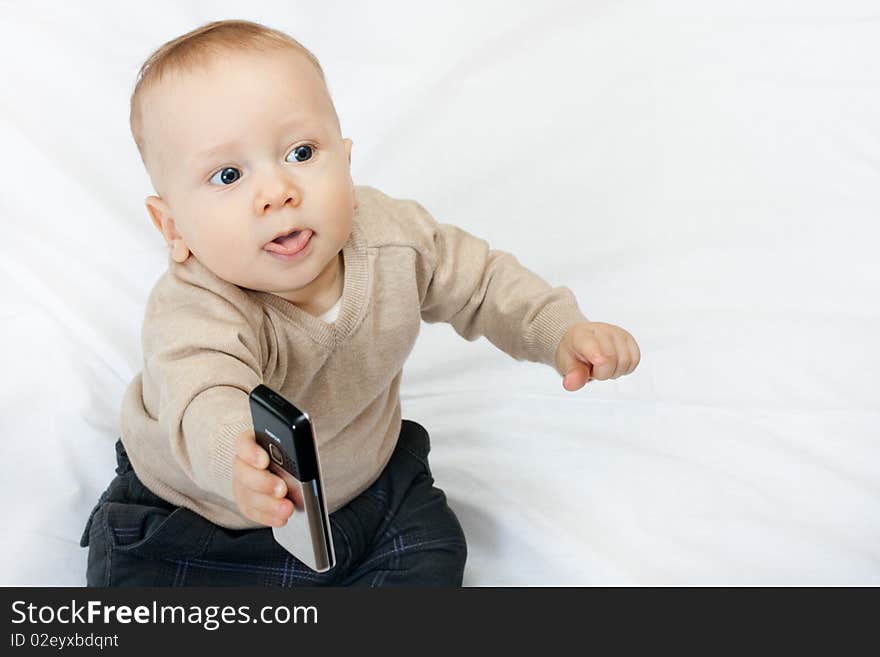 Cute baby boy playing with mobile phone on white - closeup. Cute baby boy playing with mobile phone on white - closeup