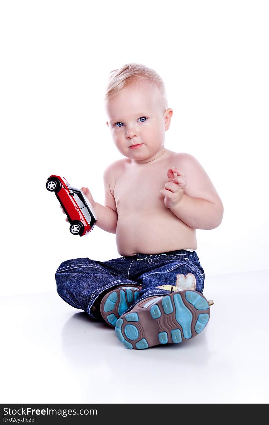 Baby boy playing with red car toy isolated on white. Baby boy playing with red car toy isolated on white