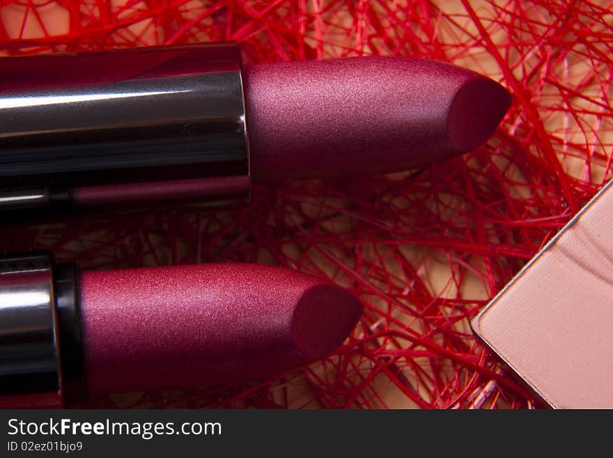 Two lipsticks on red background