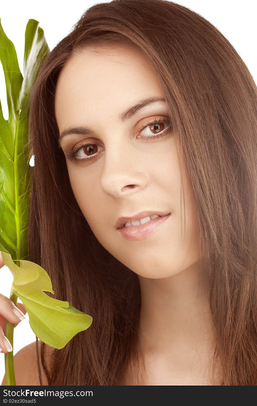 Portrait of young beautiful girl with green leaf