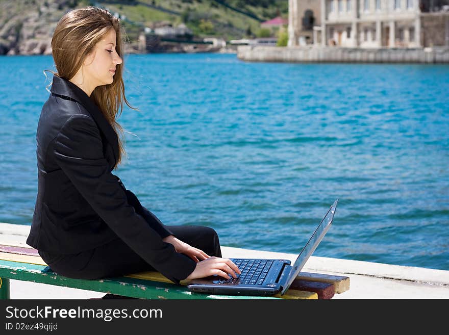 Woman with laptop near the  sea