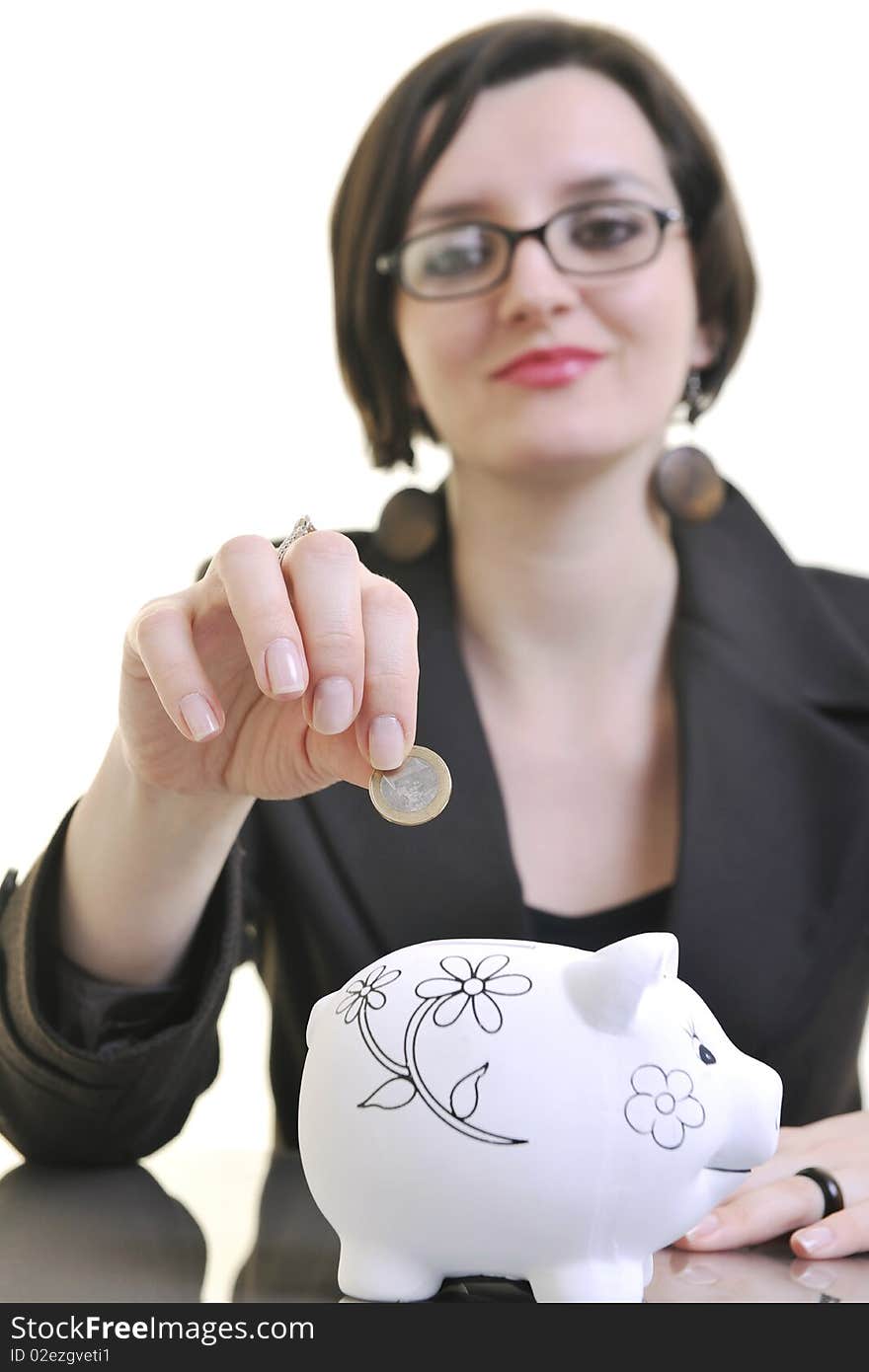 Young business woman iosolated on white putting coins money in piggy bank and representing concept of saving and smart spending money. Young business woman iosolated on white putting coins money in piggy bank and representing concept of saving and smart spending money