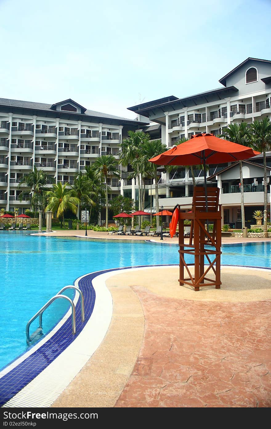 An image showing a lifeguard chair at a poolside of a luxury hotel. An image showing a lifeguard chair at a poolside of a luxury hotel