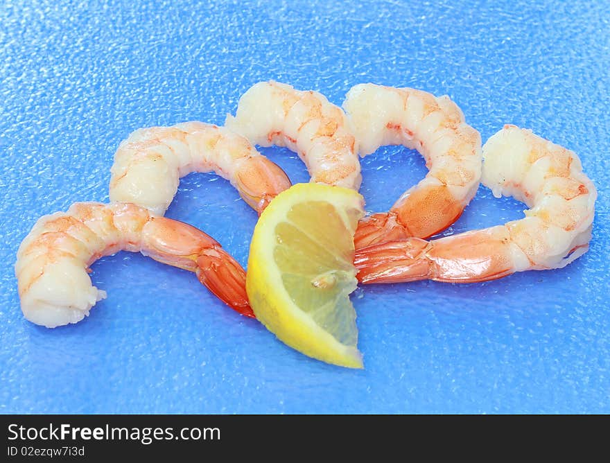 Fresh shrimp on blue background with lemon slice