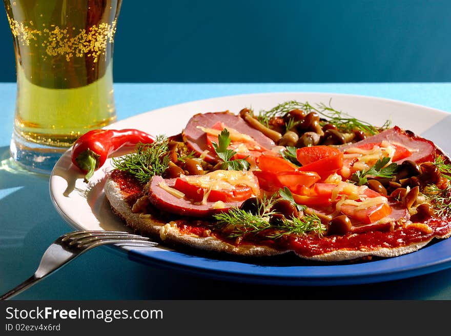 Close up of a pizza and a glass of beer