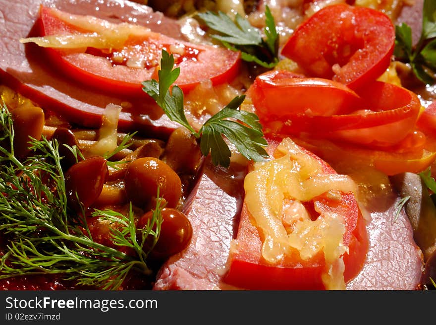 Close up of a pizza with tomatoes and mushrooms